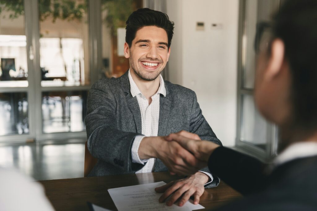 Man in a suit shaking hands at an interview.